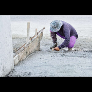 Worker leveling concrete on a construction site.