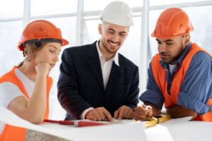 Three diverse professionals discussing blueprints at a Phoenix construction site